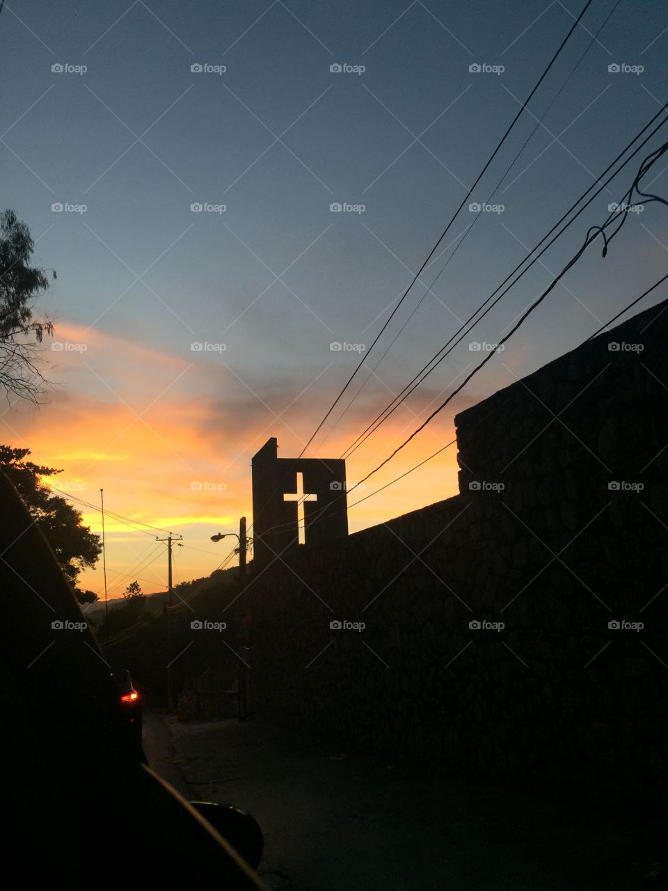 Cross on church illuminated by the sunrise...