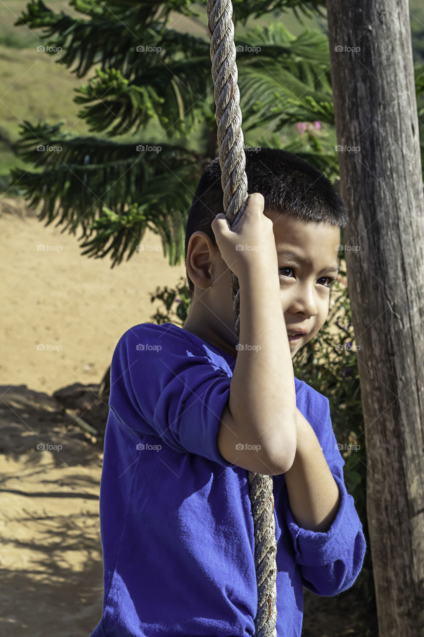 Asean boy at the nodes the rope and smiling happily.