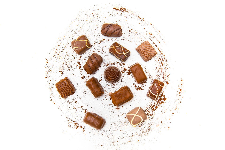 Flat lay of chocolate in round cocoa sprinkle shape. Circle shape and form on white background