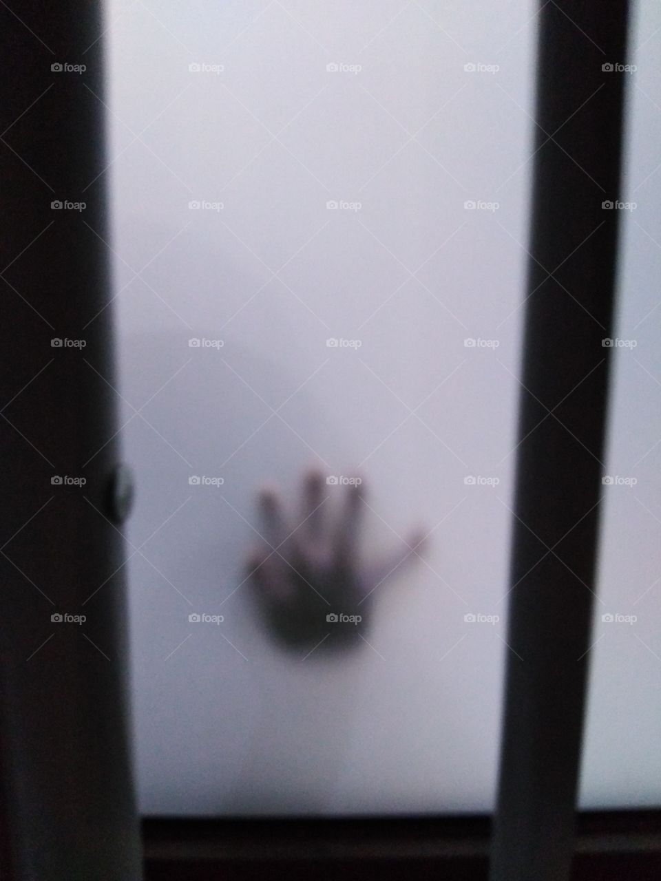 Shadow of a baby's hand through sliding door.