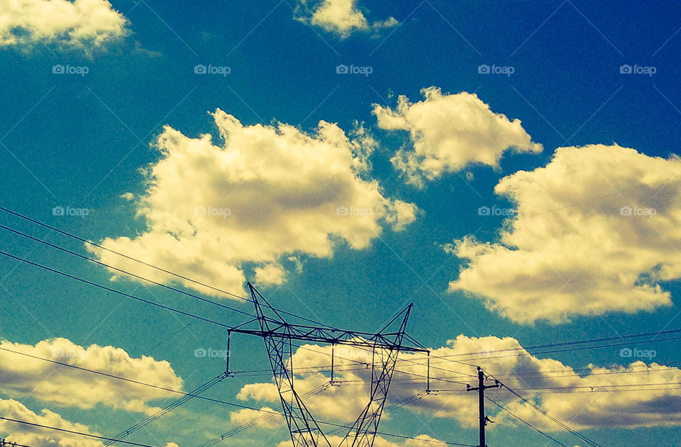 Electric Clouds. Power lines under a cloudy blue sky.