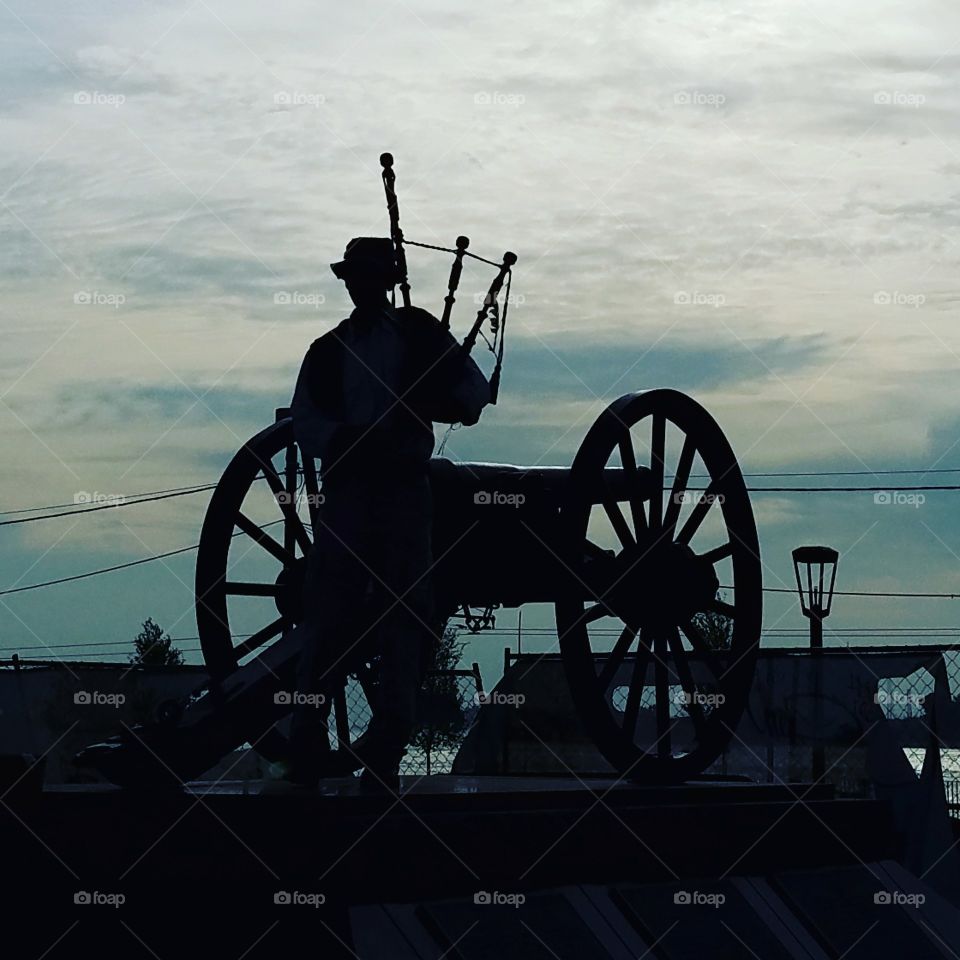 actual person playing the bagpipes on a war memorial in New Orleans.