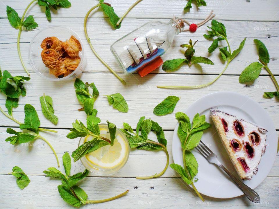 piece of cake, lemonade and mint leaves