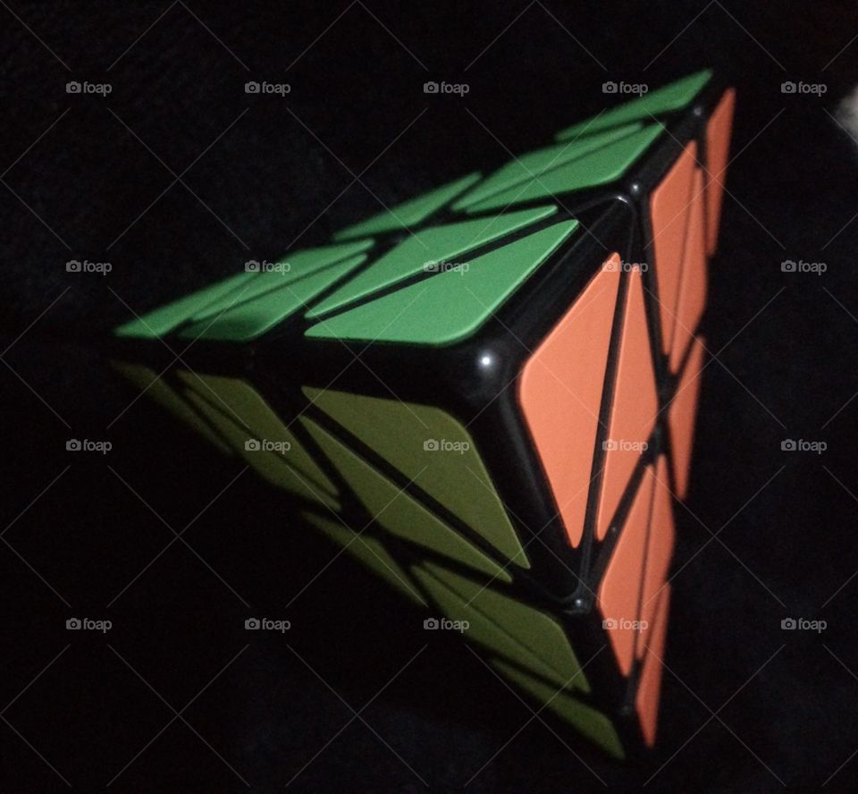 pirámide Rubik tomada desde arriba. se muestran los triángulos con colores amarillo, verde y anaranjado fosforescentes