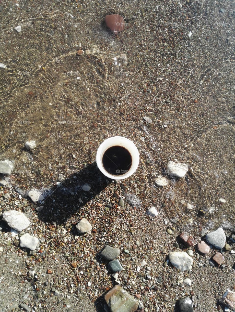 black coffee cup flat lay with beach background