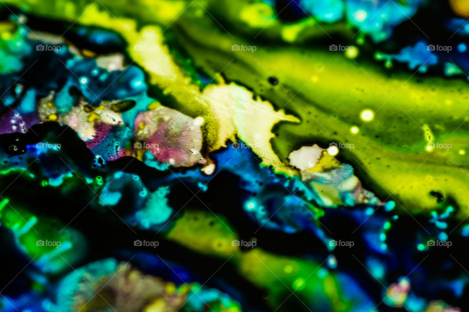 The ink to refill the printer cartridge was spilled onto the white washbasin and the paints blended into abstract drips and patterns.