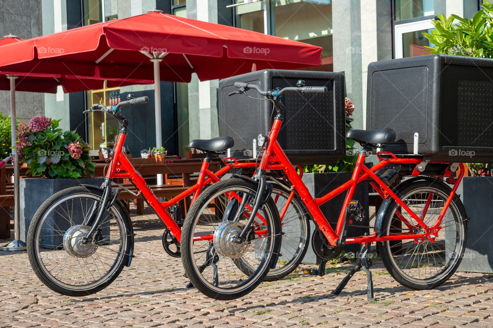 two red bicycles and delivery boxes