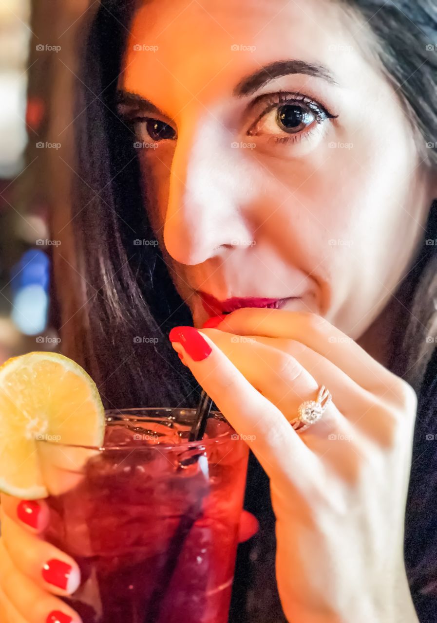 Young women enjoying a summery cocktail at a bar in Washington, DC. Close up photo of a face. 