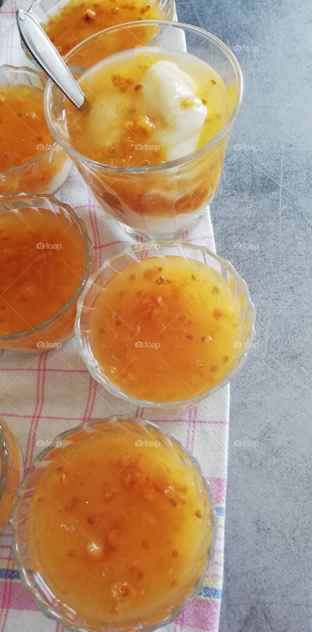 A delicious dessert made of milky custard and cloudberry kissel one on the other in the glass bowls.