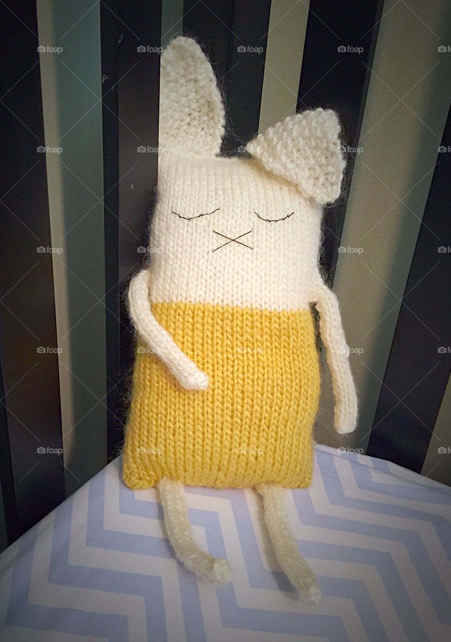 Knitted bunny . Stuffed, knitted bunny in crib