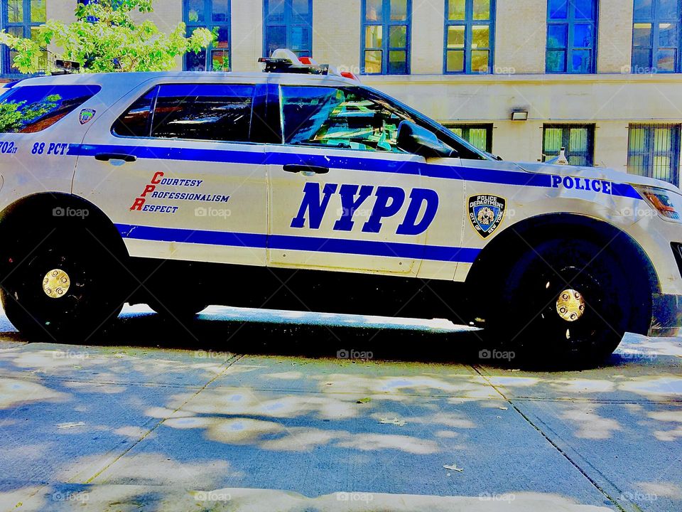 The NYPD is always around somewhere in the “Big Apple” recognizable by the white and indigo colored cars with the little rotating spotlights on top of the roof that also functions as a sirene. 2021. Hypnotic Productions