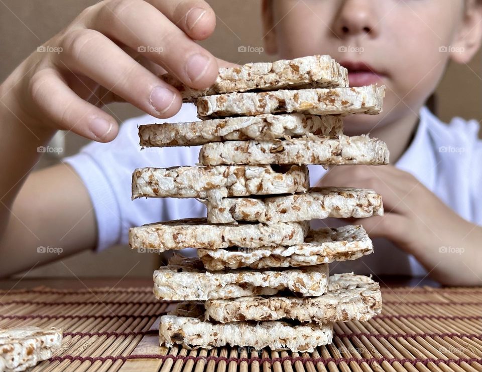 child folds a pyramid of square slides