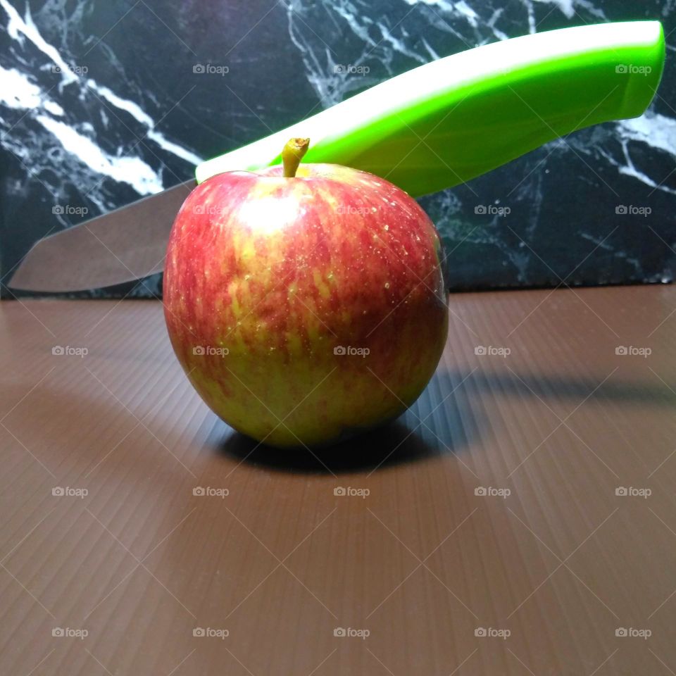 Fresh apple and green knife on the table