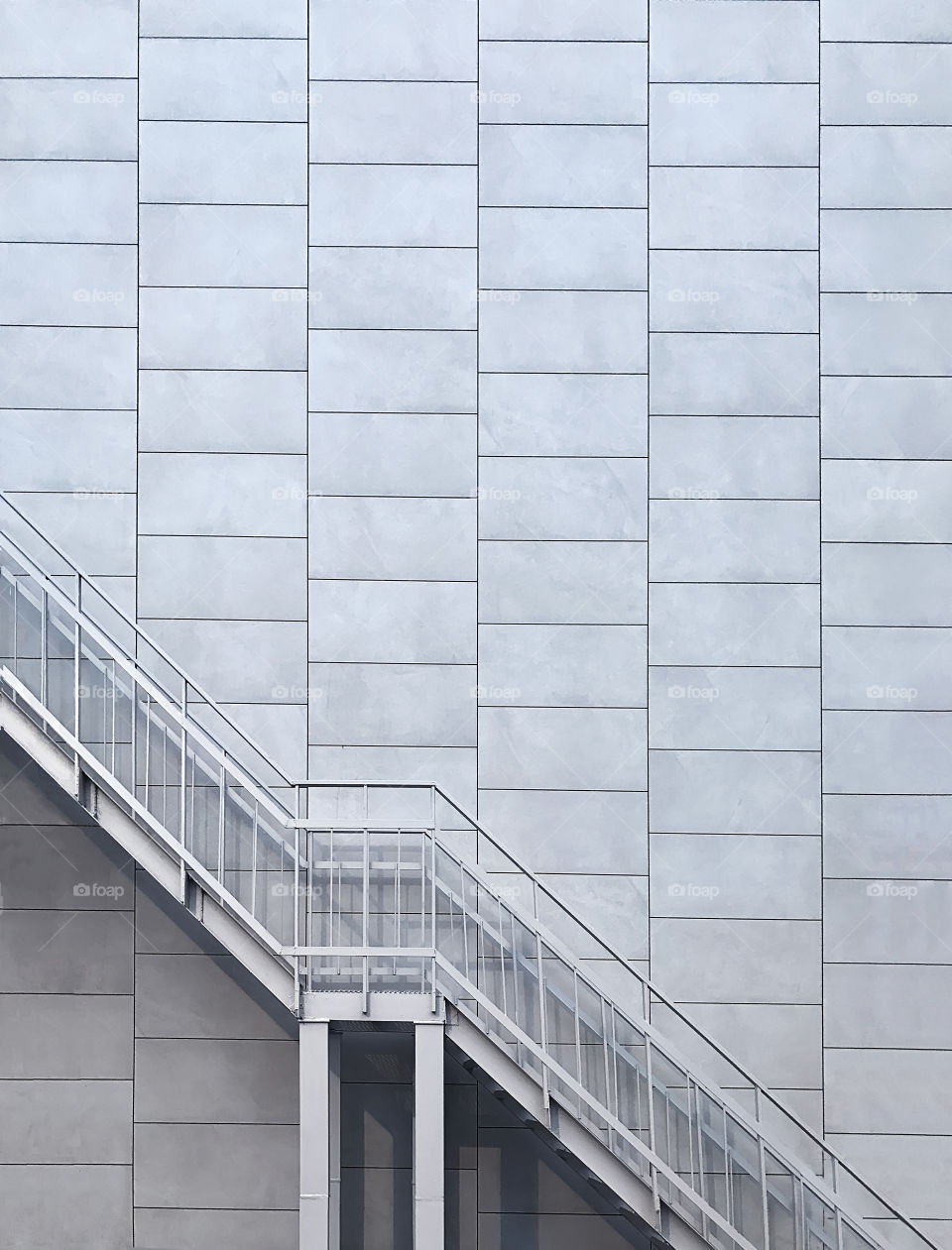 Metal stairs on geometric wall background 