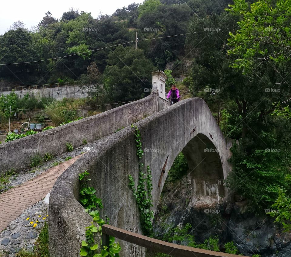 Person riding bicycle on bridge