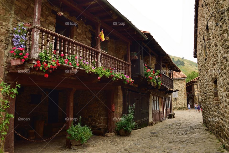 Stone walls and wooden balconies with flowers are the main characteristics of houses in Cantabria, Spain.