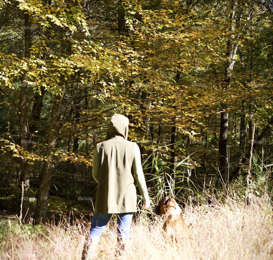 The Huntress and the Hunter; Woman in Fall attire along with her Boxer, Tucker, standing along an changing forest