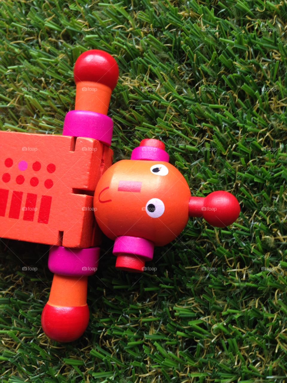 Toy robot lost in garden grass