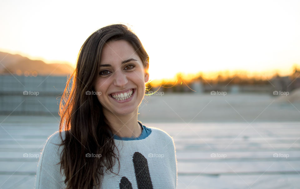 Portrait of attractive young woman against sunset