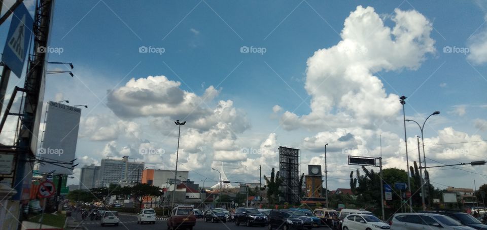 city ​​bustle under blue sky and white clouds