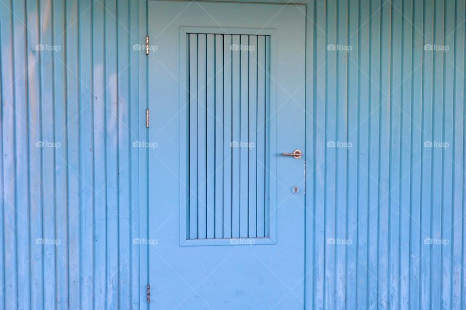 Turquoise door in turquoise wall