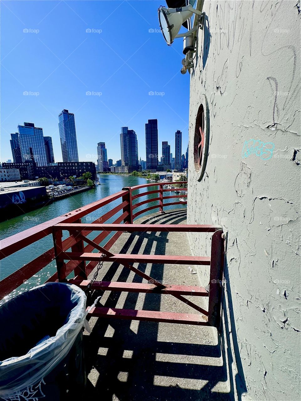 This is the central outpost of the “Pulaski Bridge” at “Newtown Creek” that connects “Greenpoint”, Brooklyn to LIC, Queens. Across the “East River” we see “Greenpoint” on the left, LIC and “Manhattan” on the right. 2024. Hypnotic Productions