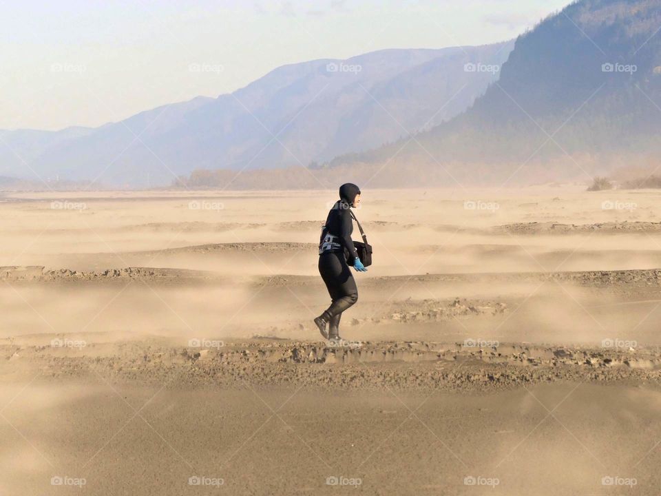 kiteboarder walking on beach in the strong wind