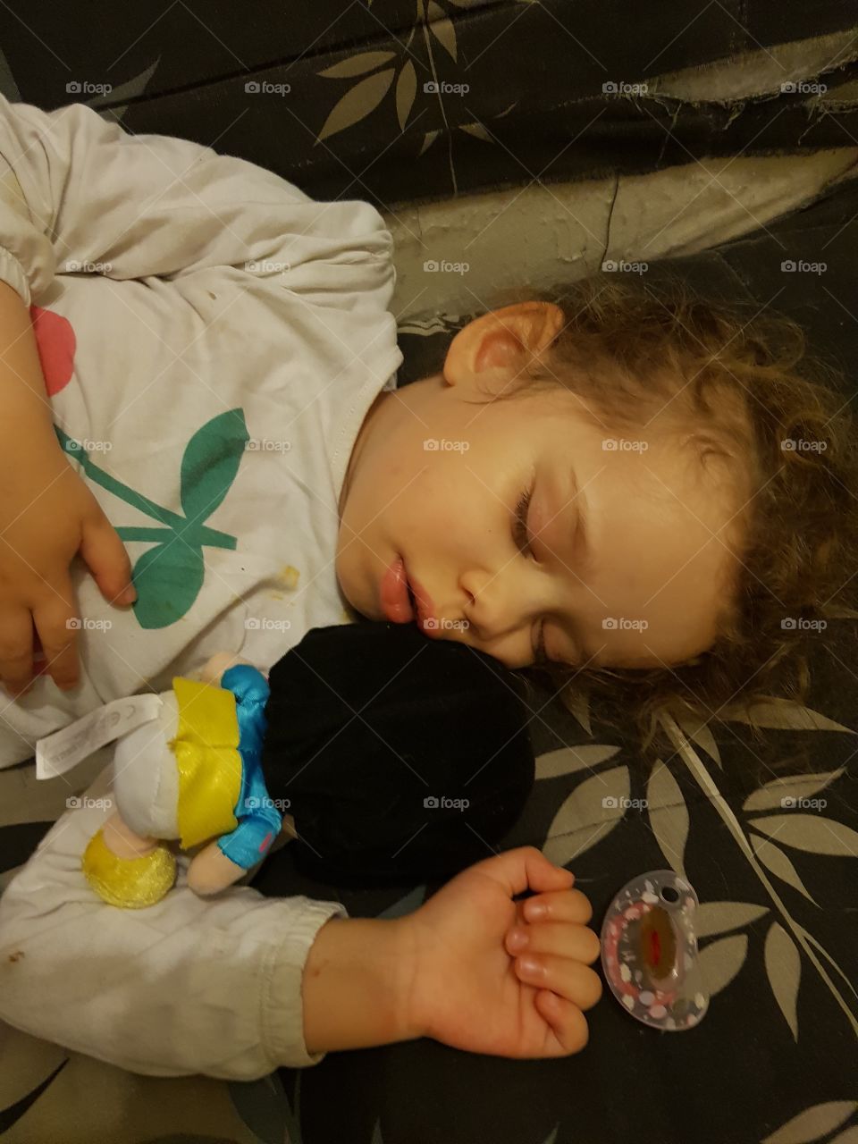 children sleeping on the sofa with her doll