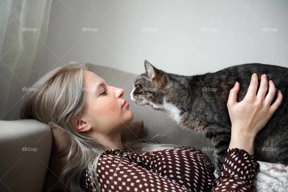 Young woman and cat on sofa