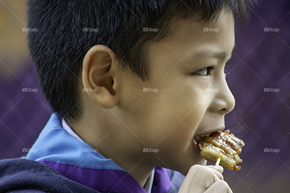 Asian boys are eating  pork roast , The food is simple and popular to eat breakfast in Thailand.