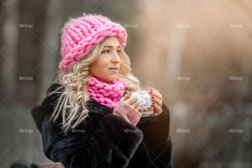 Outdoor Portrait of blonde woman in pink crochet accessories 