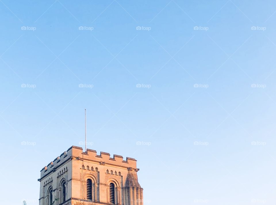 Minimal picture of English architecture against plain blue sky 