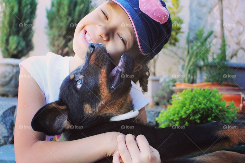 Little girl giving a tight hug to the puppy that just got home.