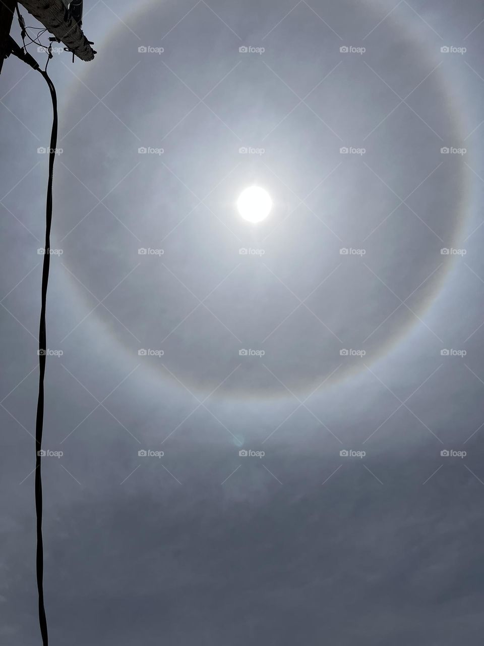 The sun with a rainbow halo around it.