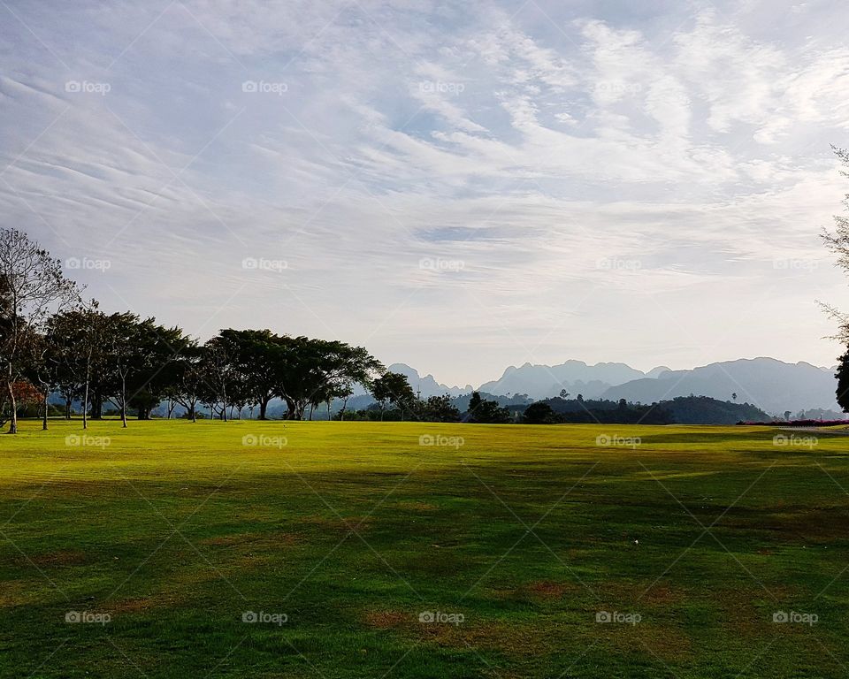 Scenic view of golf course against sky