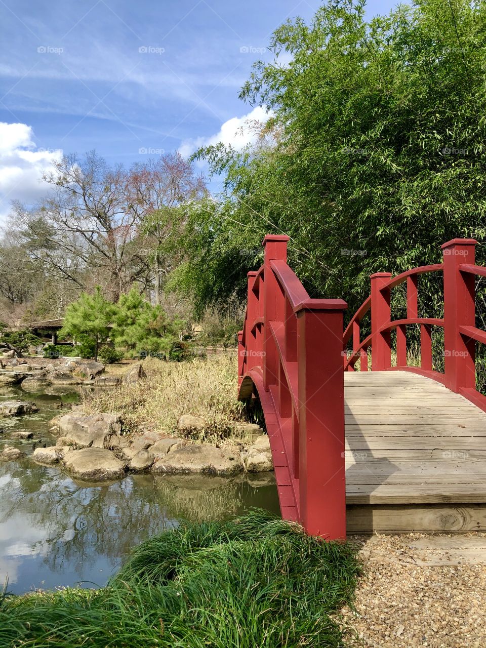 Decorative red railing on footbridge over water garden 
