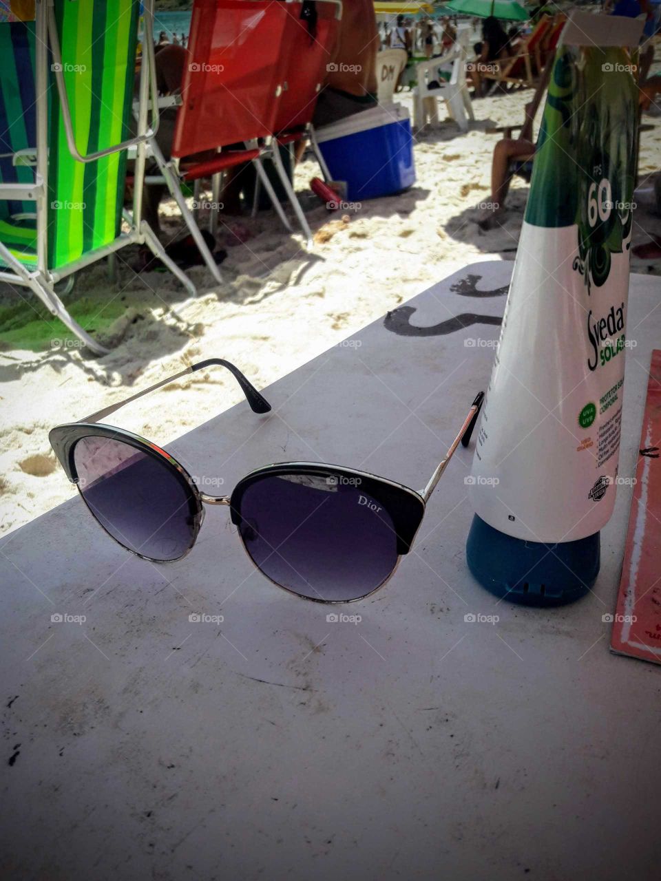 Acessórios para ir a praia, óculos escuros, bronzeador e cadeiras de Praia.