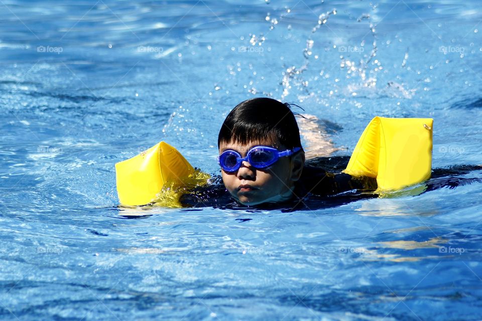 young kid swimming in a swimming pool