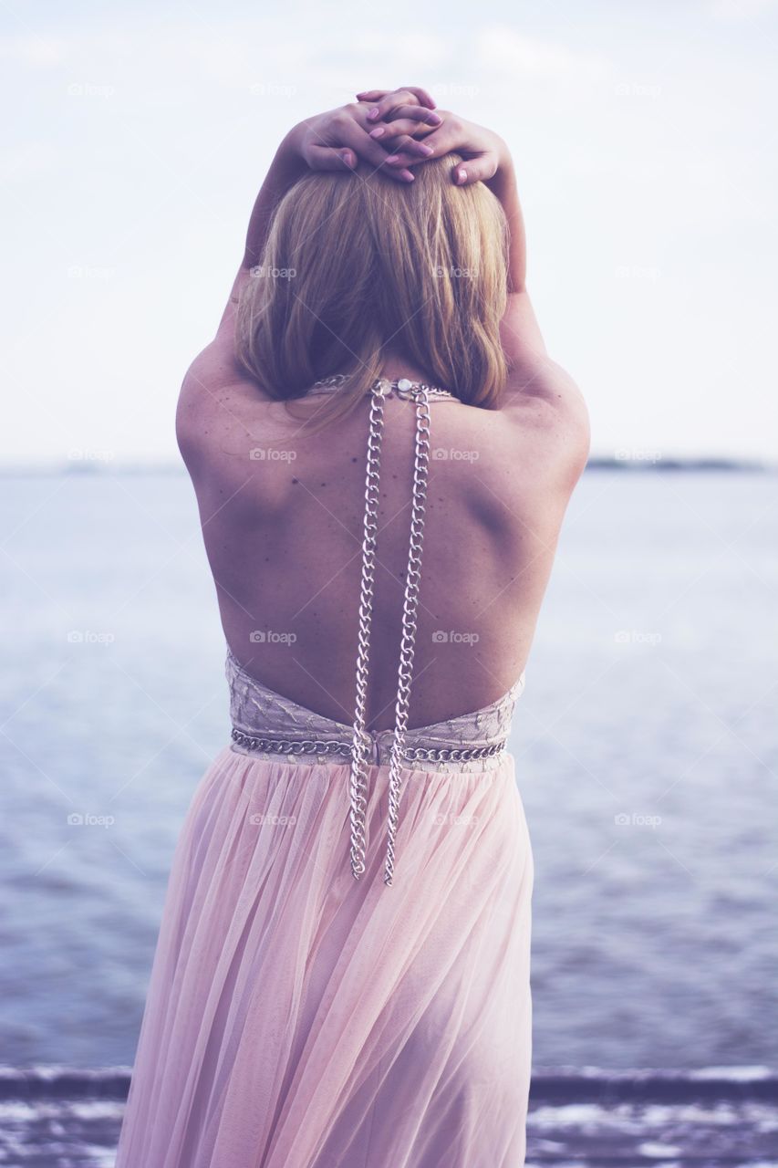 attractive woman from behind. woman in beautiful evening gown standing at lake