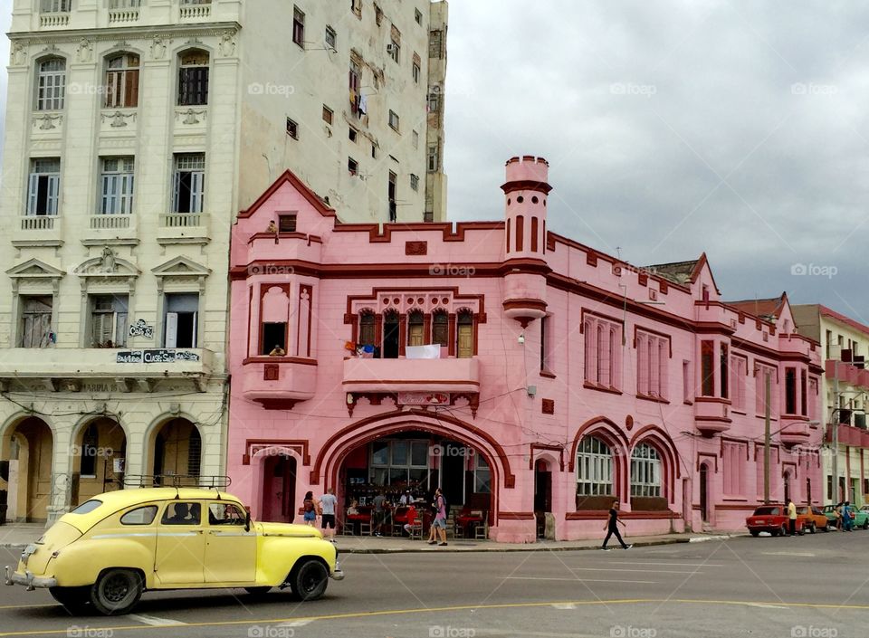 Streets of Havana, Cuba. Yellow classic car and renovated buildings.