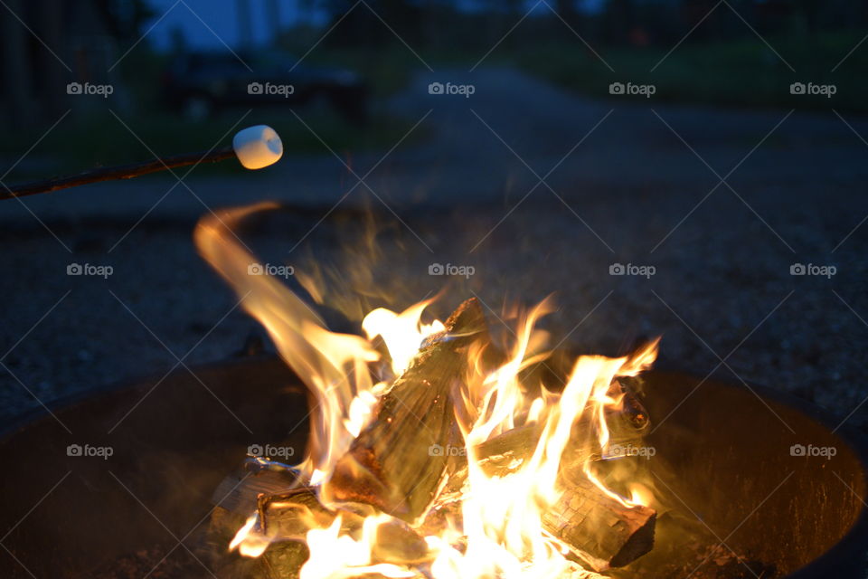 Marshmallow on a stick being roasted over a camping fire