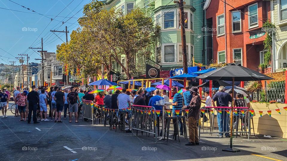 Street gathering in the Castro district of San Francisco California on a warm summer afternoon with people enjoying life 