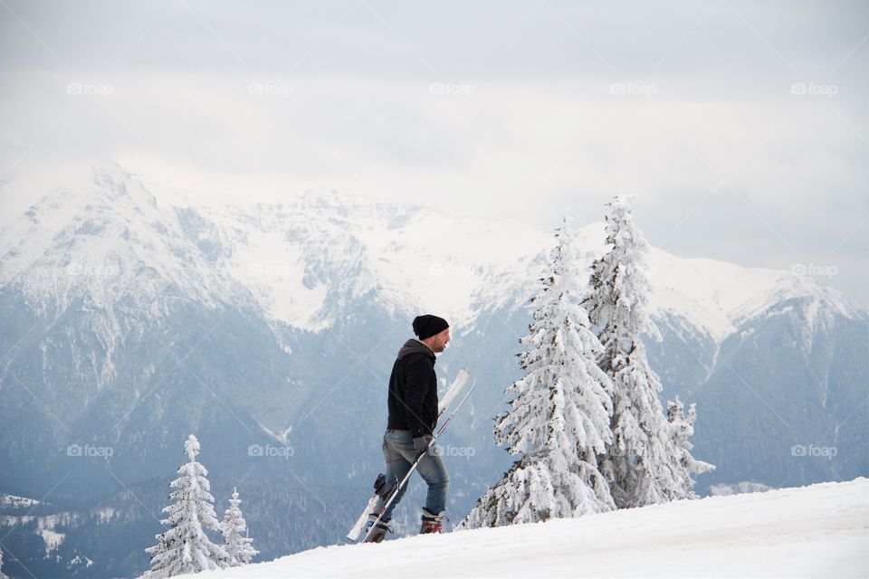 Young man snowboarding in peak Postavarul 