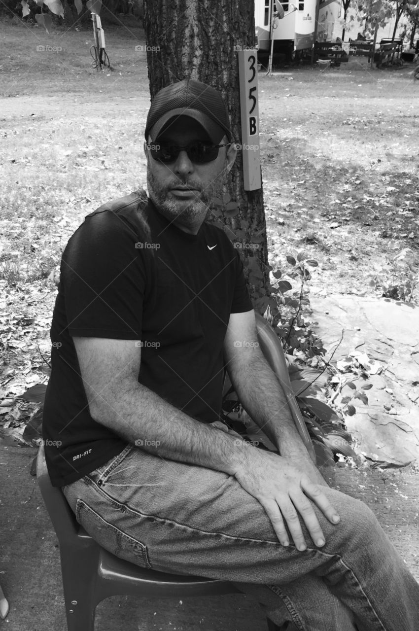 Man sitting and relaxing wearing his sunglasses and enjoying the day.