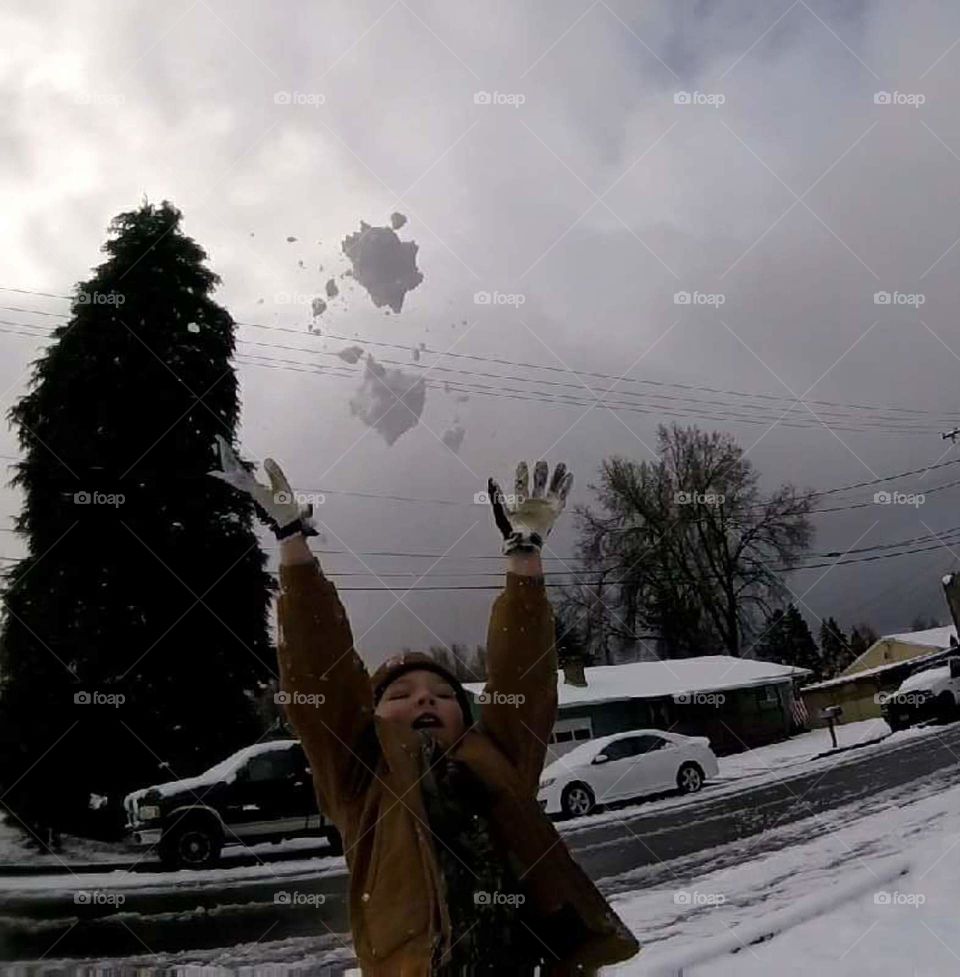 boy throws snow in the air