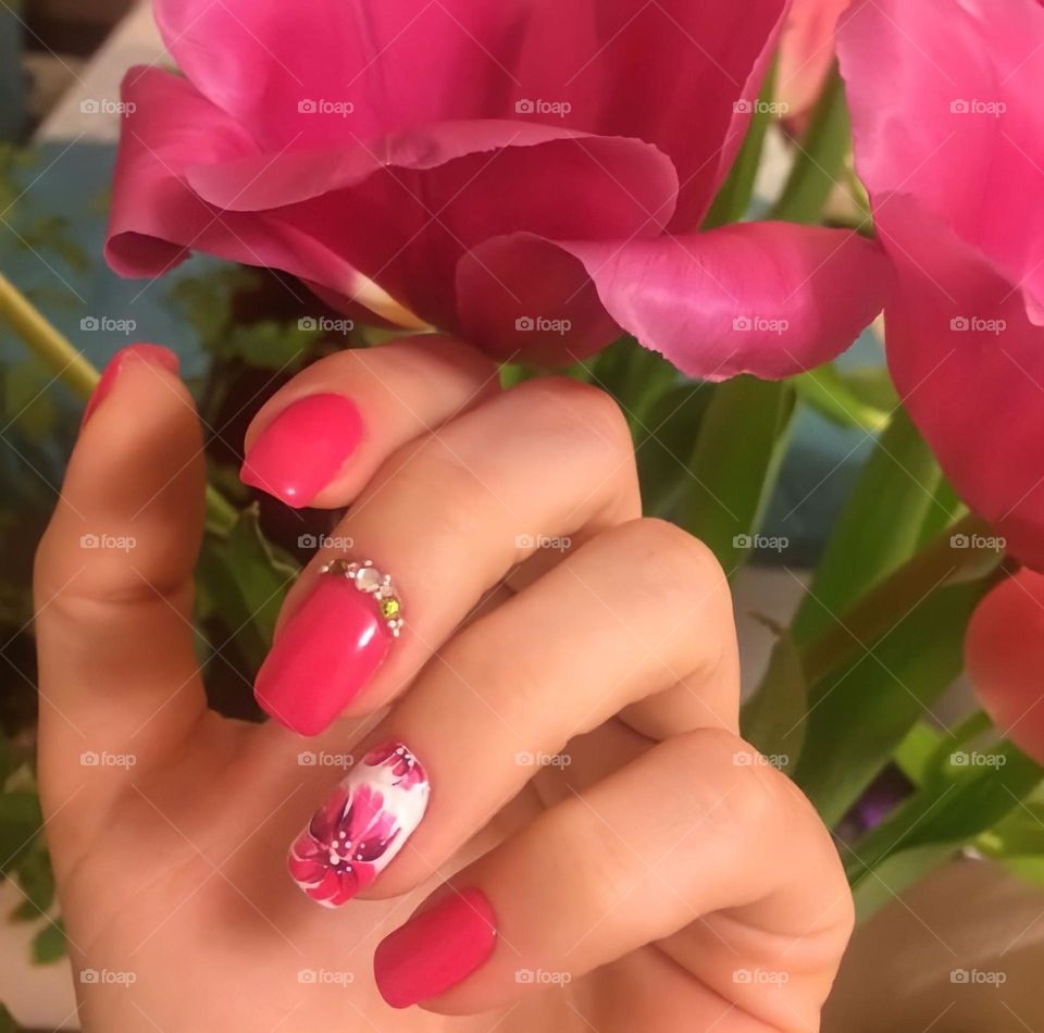 female hands with beautiful pink bright manicure drawing flowers