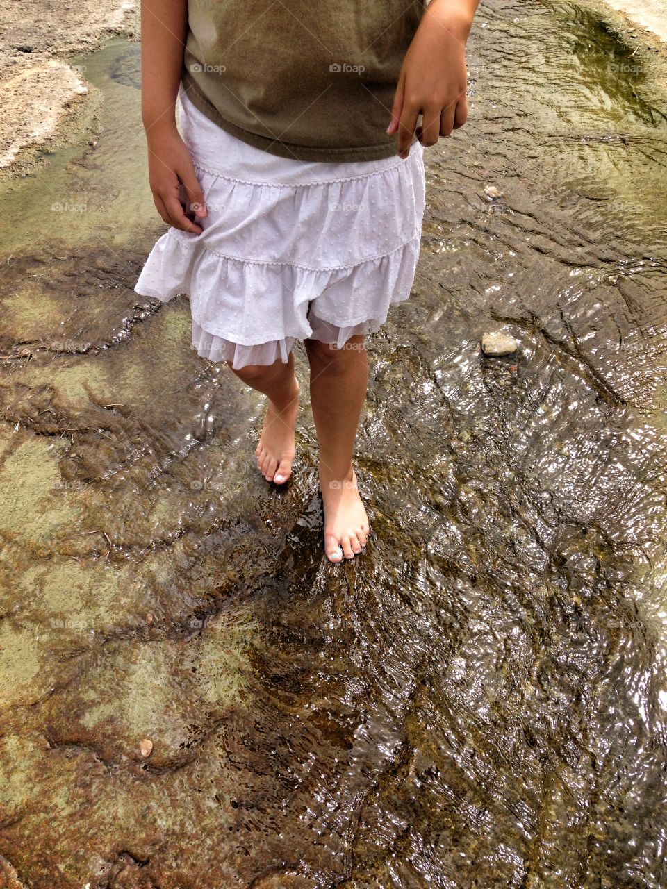 Wade with me, mama. Girl walking in a small stream of water