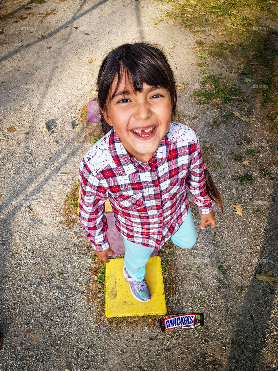 Cute little happy girl is playing hopscotch