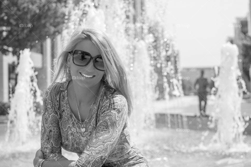 Woman in sunglasses against fountain