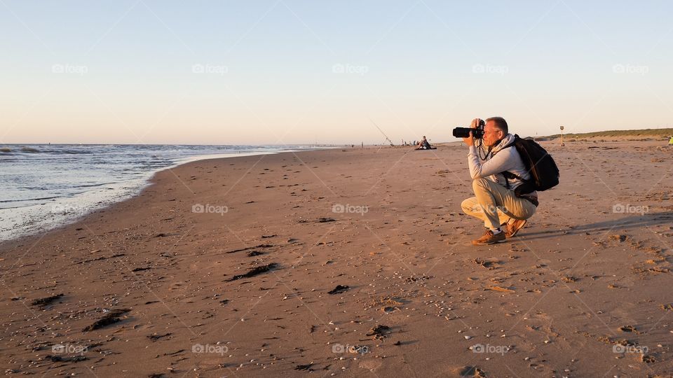 Photograher in action by sunset